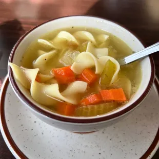 a bowl of soup with noodles and carrots