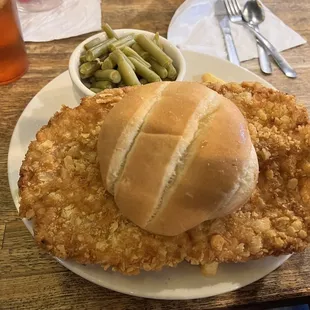 a fried chicken sandwich and green beans