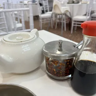 a teapot, a saucer, and a cup of coffee on a table