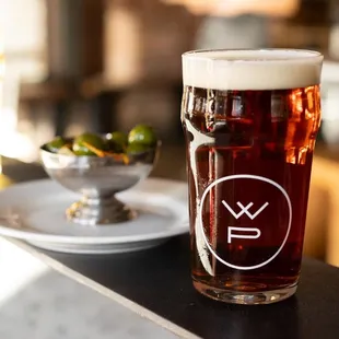 a pint of beer and a bowl of olives