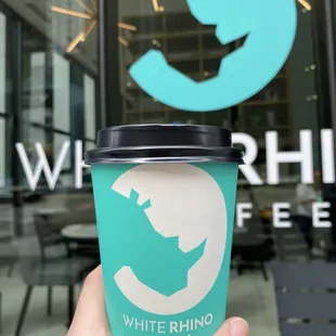 a hand holding a cup of coffee