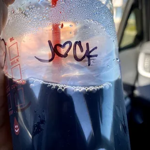 a hand holding a bottle of soda