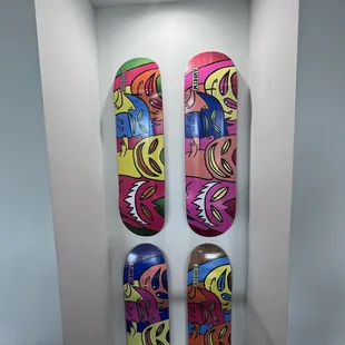 three colorful skateboards mounted on a wall