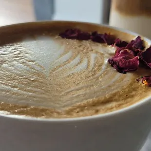 a cup of coffee with a flower on top