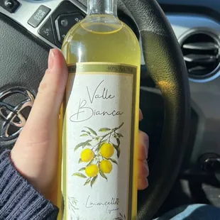 a hand holding a bottle of white wine