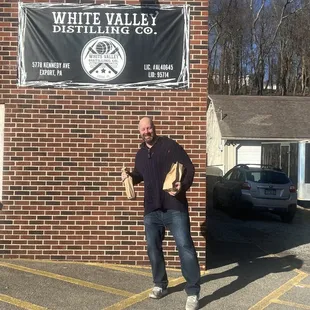 a man standing in front of a brick building