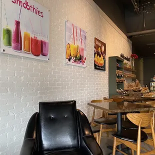 a black leather chair in front of a white brick wall