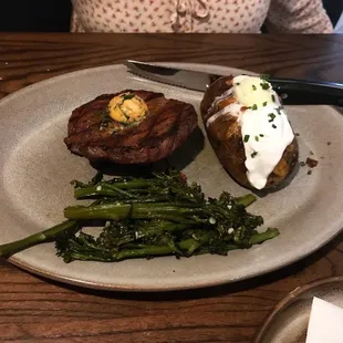 Sirloin steak with a loaded baked potato and cooked broccolini