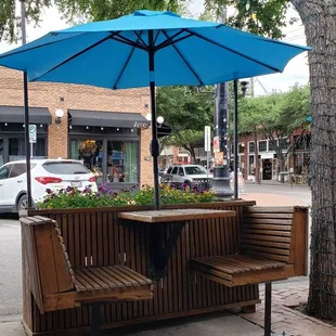 a bench and umbrella on a city street