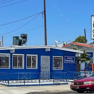 a red car parked in front of a blue building