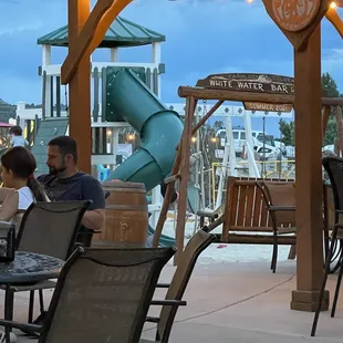 people sitting at tables under umbrellas