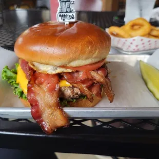 a bacon and cheese sandwich with a pickle