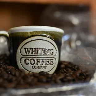 a coffee cup on a pile of coffee beans