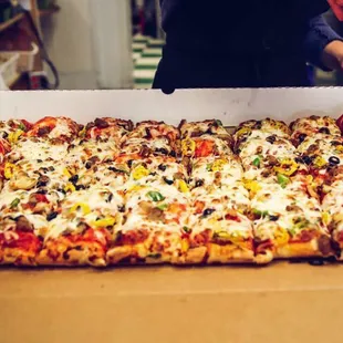 a person cutting into a pizza