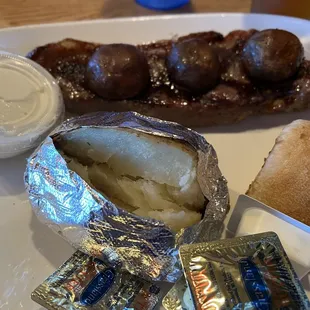Steak (NY strip) with baked potato and roll. Three marinated mushrooms included.