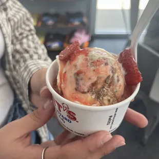 a woman holding a cup of ice cream