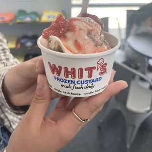 a person holding a cup of ice cream