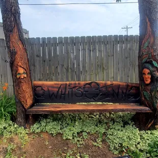 a wooden bench with carved faces