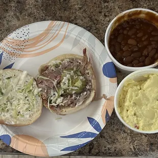 BBQ pulled pork sandwich. Small sides of beans and potato salad.
