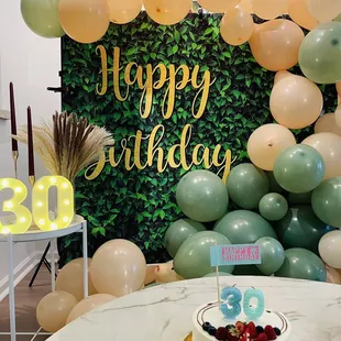 a table with a cake and balloons