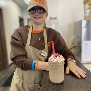 a woman in aprons holding a cup of coffee