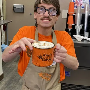 a man holding a cup of latte