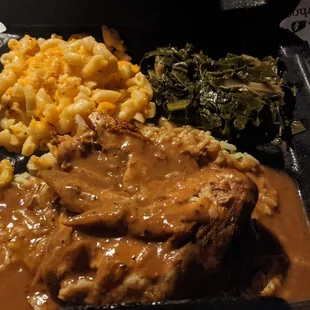 Baked chicken with gravy, yellow rice, collard greens, and Mac and cheese