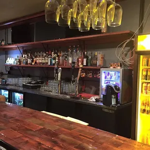 a bar with wine glasses hanging from the ceiling