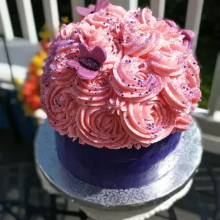 a cake with pink frosting and purple icing