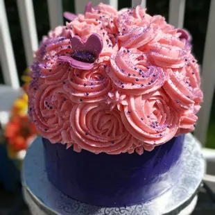 a cake with pink frosting and purple icing