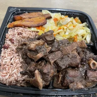 Oxtails, rice and peas, steamed cabbage and plantains.