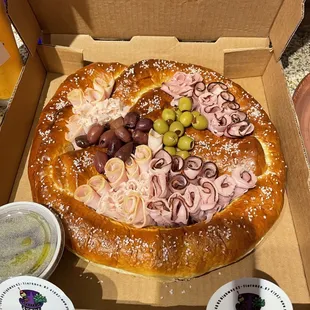 a pretzel with olives, ham, and olives