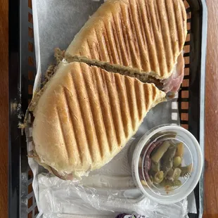  a sandwich and pickles in a basket