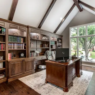 a home office with a desk and bookcases
