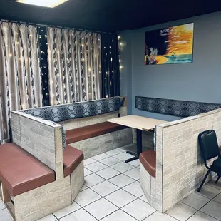 a corner booth with a table and chairs