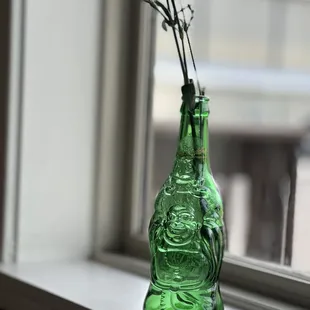 a green glass vase with flowers in it