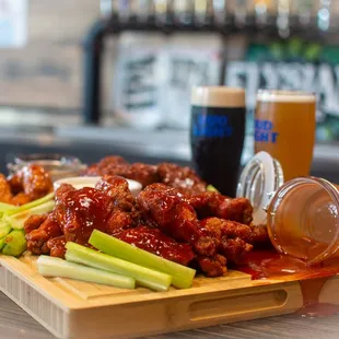 a tray of wings, celery, and beer