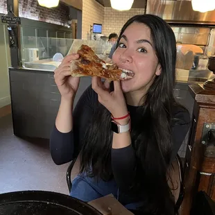 a woman eating a slice of pizza