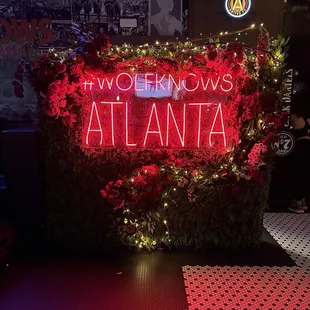 a neon sign in front of a floral display