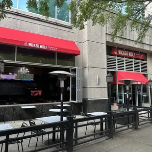 the outside of a restaurant with tables and umbrellas