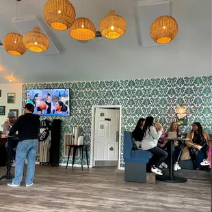 a group of people sitting at tables in a restaurant