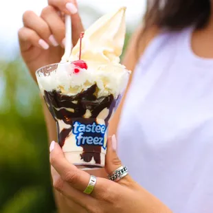 a woman holding a cup of ice cream