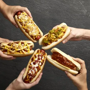 a group of people holding hotdogs