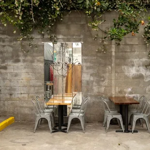 a table and chairs in front of a brick wall