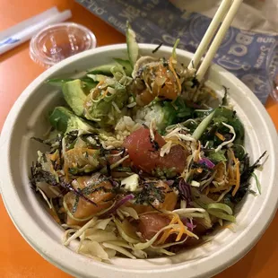 a bowl of food with chopsticks
