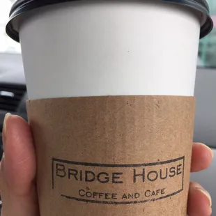 a hand holding a coffee cup
