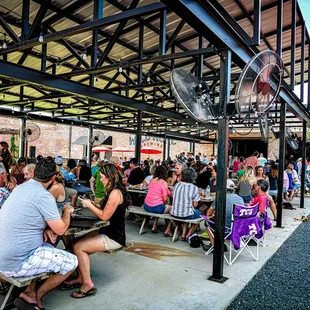 a large group of people sitting at picnic tables