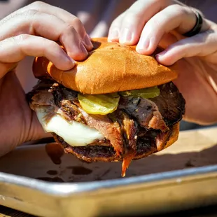 a man holding a pulled pork sandwich