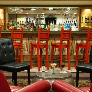 a bar with red chairs