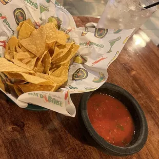 a bowl of chips and a glass of water